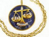 un collier en or orné d'une balance de la justice