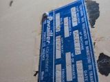 a blue and white sign on the floor of a bathroom