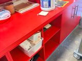 a red counter with a bunch of items on it