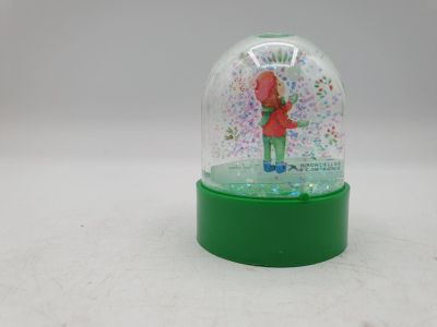 une boule à neige avec une personne à l'intérieur, posée sur une table