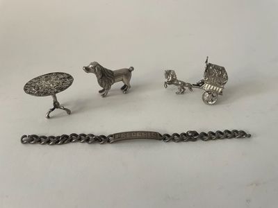 three pieces of silver jewelry including a horse drawn carriage, a bracelet, and a bracelet