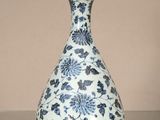 un vase bleu et blanc posé sur une table en verre