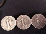 three silver coins sitting next to each other on a black surface