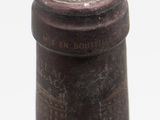 a close up of a bottle of wine on a white surface