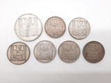 un ensemble de cinq pièces d'argent présentant des motifs différents