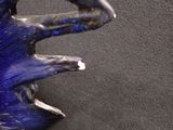 a blue and black sculpture of a hand holding a flower