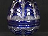 an image of a blue glass egg on a stand