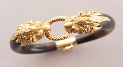 a close up of a bracelet with two lions on it