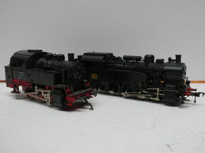 un train noir et rouge posé sur une surface blanche