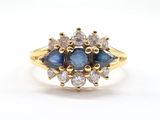 un gros plan d'une bague en or jaune sertie de diamants bleus et blancs