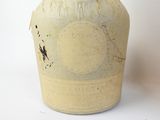 a white vase with a brown handle sitting on a white surface