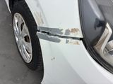 a white car that has a dent in the front of it