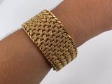 a close up of a person ' s hand wearing a gold bracelet