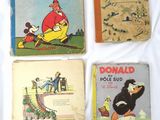 quatre livres pour enfants posés sur un lit recouvert d'un drap blanc