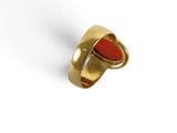 Gros plan sur une bague en or ornée d'une pierre rouge