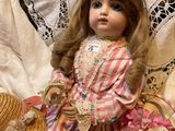 a doll that is sitting on a bed with a hat