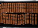 de nombreux livres anciens dans un coffret noir posé sur une table