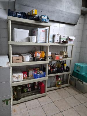 une pièce dans laquelle se trouvent des étagères et des bacs remplis de nourriture