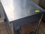 une table en acier inoxydable dans une cuisine, sur laquelle est collé un autocollant jaune