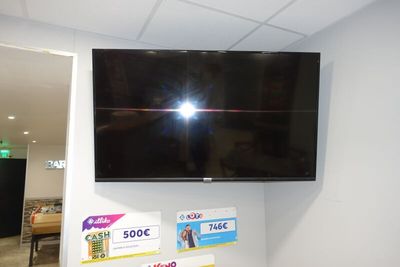 un téléviseur à écran plat fixé au mur dans un coin de la pièce