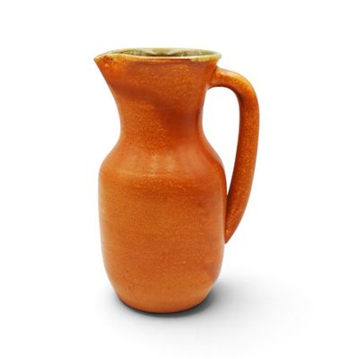 an orange pitcher that is sitting on a white surface