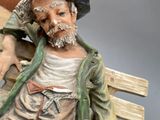 a figurine of a man sitting on a bench