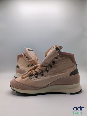 La chaussure est rose et comporte un lacet sur le côté.