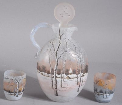 un pichet blanc et des tasses posés les uns à côté des autres sur une table