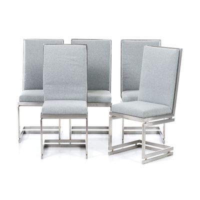 quatre chaises avec une assise rembourrée grise et un piètement en métal argenté