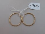 deux paires de boucles d'oreilles créoles en or avec une étiquette de prix sur fond blanc