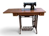 une vieille machine à coudre posée sur une table en bois