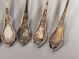five spoons are lined up in a row on a table