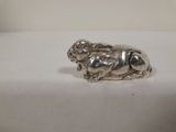 une figurine en argent représentant un chien assis sur une table