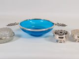 three pieces of silver and blue glass on a white surface