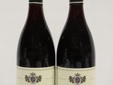 two bottles of wine sitting next to each other on a table