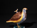 a close up of a figurine of a bird on a pedestal