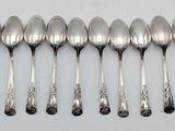 six spoons are lined up in a row on a white surface