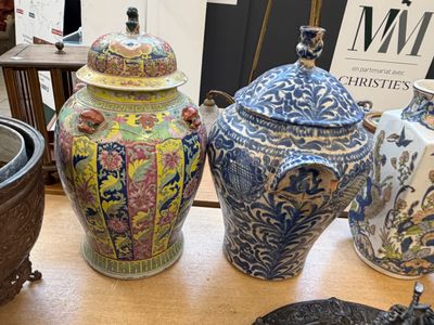 de nombreux vases posés sur une table, avec un livre en arrière-plan