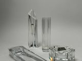 trois objets en verre transparent posés sur une surface blanche