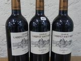trois bouteilles de vin posées sur une table en bois