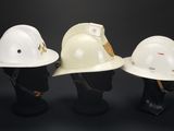 three white hard hats sitting next to each other on top of a mannequin head