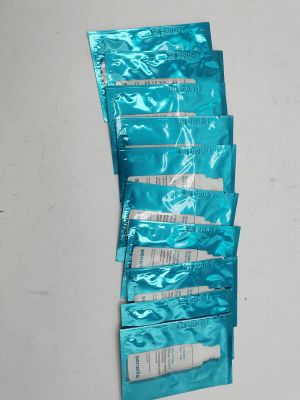 plusieurs tubes de dentifrice posés sur un mur blanc