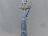 un vase bleu surmonté d'un oiseau