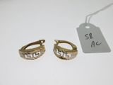 deux paires de boucles d'oreilles en or posées sur une surface blanche, accompagnées d'une étiquette de prix