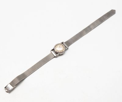 un gros plan d'une montre sur une surface blanche avec un fond blanc