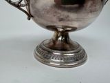 a silver cup that is sitting on top of a table