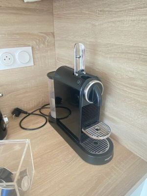 une machine à café noire posée sur le plan de travail d'une cuisine