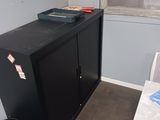 une armoire noire dans un coin d'une petite pièce