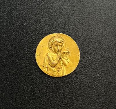 a close up of a gold coin on a black surface