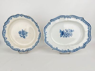 two blue and white plates with flowers on them on a white surface
